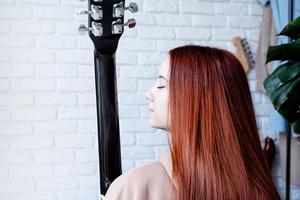 mujer joven, tocar la guitarra, en casa foto