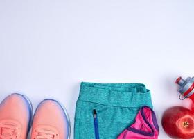 zapatillas deportivas rosas y una botella de agua roja foto