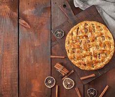 tarta de manzana redonda entera horneada en una tabla de madera marrón foto