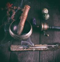 copper singing bowl and a wooden stick photo