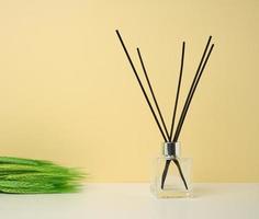 glass flask and wooden sticks, aroma lamp on colored background photo