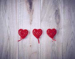 tres corazones rojos tallados en un palo foto