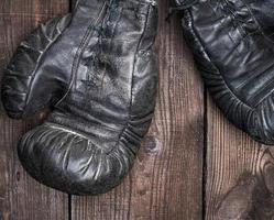 pair of very old shabby black leather boxing gloves photo