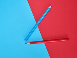 red and blue wooden pencils on color abstract background photo