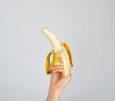 peeled fresh banana in female hand photo