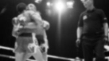 Blurred images black and white photo style of Thai boxing or Muay Thai or Kickboxing which local and foriegn boxer are fighting on the ring at indoor stage as martial art sport. Muay Thai Kick boxing