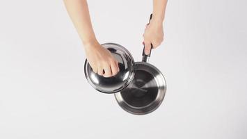 Pot cleaning Man hand on white background cleaning the non stick pot with handy dish washing sponge which yellow color on the soft side and green on hard side for hygiene after cook. Electric pot photo