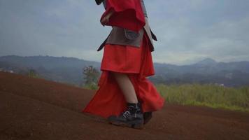 una mujer china vestida de guerra caminando desesperadamente por la montaña con suelo marrón en el fondo video