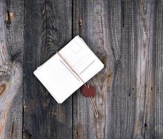 stack of paper cards tied with a rope with a stamp on a gray old wooden background photo