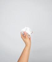 female hand holding white crumpled paper photo