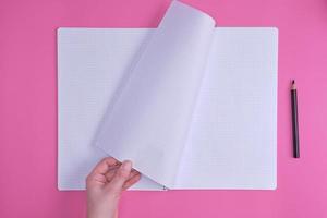 empty open notebook in a cell and a female hand photo