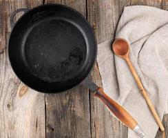 empty black round frying pan with  handle and spoon photo