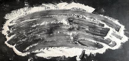 white wheat flour scattered on a black table photo