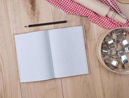 open notebook in a cell, round wooden sieve photo