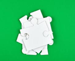 blank white big puzzles on green background photo