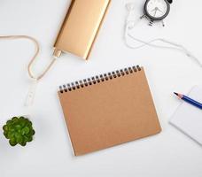 spiral notebook with empty sheets, pen and green plants photo