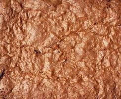 fragment of baked brownie chocolate cake with cracked surface photo