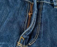 iron yellow zipper on the fly on blue jeans photo