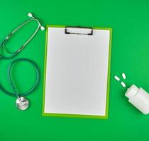 paper holder with empty white sheets, medical stethoscope photo