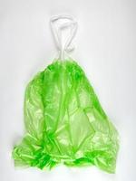 empty transparent  green plastic garbage bag with handles photo