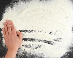 white wheat flour scattered on a black background photo