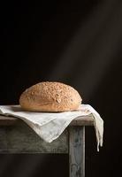 baked round rye bread lies on a gray linen napkin photo