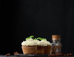 Baked cupcakes with white butter cream on the table, delicious dessert photo