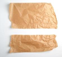 torn brown pieces of parchment paper on a white background photo