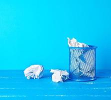 blue metal bucket filled with crumpled white paper photo