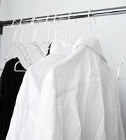 white men's crumpled shirts hanging on a metal hanger photo