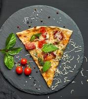 delicious triangular slice of pizza with smoked sausages, mushrooms, tomatoes photo