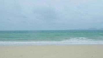 sand mit unscharfem tropischem strand-bokeh-hintergrund der ozeanwasserwelle, sommerferien und reisekonzept mit kopienraum, thailand video