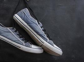 pair of textile blue sneakers hang on a string photo