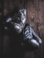 ,  black leather boxing gloves hanging on a nail photo