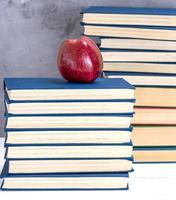 ripe red apple on a stack of books photo