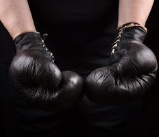 manos de un atleta con viejos guantes de boxeo deportivos marrones foto