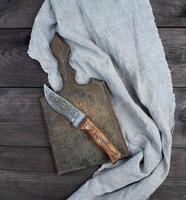 tablero de cocina de madera antigua y cuchillo vintage foto