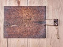 very old brown square cutting board with a handle photo