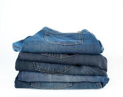 stack of folded blue jeans on a white background photo