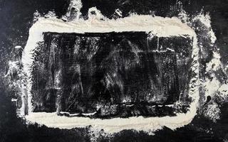 harina de trigo blanca esparcida sobre un fondo negro foto