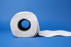 twisted roll of white paper towel on a blue background photo