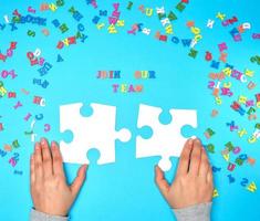 women's hands hold two large white puzzles and the inscription join our team photo