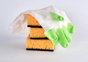 pila de esponjas de cocina amarillas para lavar platos y guantes foto