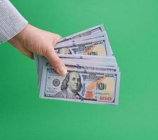 hand holding paper money on a green background photo