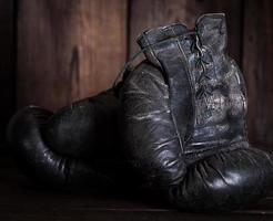 pair of very old shabby black leather boxing gloves photo