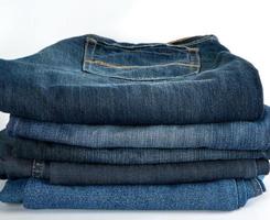 stack of folded blue jeans on a white background photo