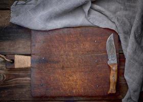 tabla de cortar de madera marrón vacía muy antigua con mango foto