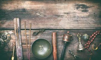 Copper singing bowl, prayer beads, prayer drum and other Tibetan religious objects for meditation photo