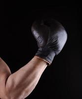 man's hand is wearing a brown leather boxing glove photo