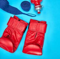 pair of red leather boxing gloves and a textile bandage photo